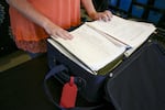 Mia Storm looks at a suitcase full of her medical records and reports from the 14 years she spent in the foster care system. She was shuffled through nearly 20 foster homes and heavily medicated in the years she spent under state supervision. Now 32, she is working to gain her independence and raise her daughter Lily.