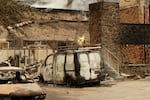 A charred van is parked by a building that burned down on W. Indian Trail Rd. in the aftermath of a wildfire in Spokane, Wash., Sunday, Aug. 2, 2026.