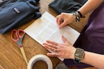 Rachael Z. Miller, founder of the Vermont-based Rozalia Project for a Clean Ocean, conducts a tape test on various clothing items to compare how much each material sheds microfibers on Thursday, April 17, 2025, in Granville, Vt.