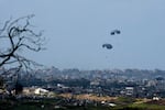 Parachutes carrying humanitarian aid dropped from an aircraft into Beit Hanoun, northern Gaza Strip, seen from southern Israel, Monday, March 25, 2024.