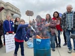 Families gathered at the Idaho Capitol building on Saturday, March 6, 2021, to burn masks at a protest over COVID-19 restrictions.
