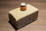 The "Meju doughnut" has sticky rice with caramelized cream inside, black garlic puree and a millet rick cake on top, presented on a meju — a brick of fermented soybeans.
