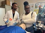 Jerrian Reedy, left, a student at the University of Mississippi School of Medicine, assists Dorothy Gray, a student at Northside High School in the Mississippi Delta, as she practices intubation in a simulation lab. Gray, who is interested in pursuing a career in the mental health care field, attended the University of Mississippi School of Medicine’s annual African American Visit Day in April. 