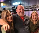 A picture of Douglas Diamond with his arms around his two daughters, Chelsea and Desiree.