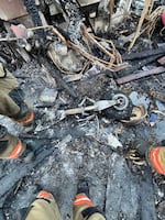 Firefighters stand around the debris of the crashed Cessna 421C aircraft in Fairview, Ore., on Aug. 31, 2024.