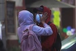 A couple wears hoods and masks Monday to protect themselves from the ashfall of the Popocatépetl volcano in Atlixco, Mexico.