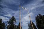 A logger climbed all the way to the top of the timber poles at the center of the festival.