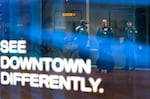 Portland Police Bureau’s bike squad members, including Portland Police Sgt. Jerry Cioeta, center, reflected in a downtown business window while awaiting transport for a man on a fentanyl-related charge on Feb. 7, 2024. The work is part of a pilot program by Portland Police Bureau’s bike squad and addiction recovery providers that launched in December 2023.