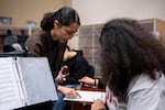 Cindy Flores works with a student in her mariachi class at McKay High School in Salem, Ore., on March 10, 2026. Federal aid allowed Flores, a Flores, a Portland State University music education graduate, to get her college degree rather than work in fast food, she said.