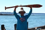 Albert Ortivez-Hicks, 18, Quinault, holds his paddle, made for him by his grandmother Mary Shale, after the final pull to Puyallup on July 31, 2024. His paddle snapped in half during the last few dozen feet before shore.