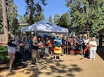 Community members gather at the Phoenix Library for a ribbon cutting, celebrating the opening of the library's new pollinator garden
