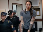 WNBA star and two-time Olympic gold medalist Brittney Griner is escorted from a court room ater a hearing, in Khimki just outside Moscow, Russia, Thursday, Aug. 4, 2022.