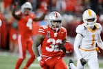 Ohio State running back TreVeyon Henderson, front, scores a touchdown against Tennessee during the second half in the first round of the College Football Playoff, Saturday, Dec. 21, 2024, in Columbus, Ohio.