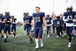 Cooper Winn (20) leads his team into the locker room at halftime of the Oregon 6A football championship at Hillsboro Stadium in Hillsboro, Ore., Saturday, Dec. 7, 2019. Central Catholic defeated Lake Oswego 49-28.