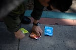 Wilson Linares, commander of the L.A. County law enforcement division of the California Dept. of Cannabis Control, shows a sampling of the unlicensed cannabis edibles seized from a black market store in Long Beach, Calif., on March 5.