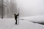 Eric Meyer uses a hollow pole thrust into the ground to measure the snow in Sequoia National Park in Round Meadow.