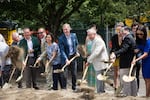 Mayor Ted Wheeler, center, blue suit, and others break ground at the site of a future Ritz-Carlton luxury hotel in Portland, Ore., Friday, July 12, 2019. The hotel has displaced the Alder Food Carts, which had occupied the space since the late 1990s.