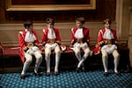 Page boys sit together before lining up for the arrival of Queen Elizabeth II at the Palace of Westminster for the State Opening of Parliament on Oct. 14, 2019.