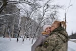 Yulya Dmytrieeva and her husband, Vadym, who have been together for over a decade, embrace in the snow in Sloviansk. They will spend a few days together while he has a break from the trenches on the front lines.