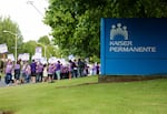 Dozens of health workers rallied outside Kaiser Permanente's Cascade Park campus in Vancouver, Wash., in support of labor negotiations for a new contract Tuesday, July 23, 2019.