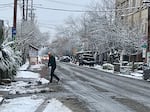The streets of Portland were relatively quite Tuesday morning after the city received two inches of snow. A shopkeeper along Southeast Division Street in Portland worked to clear parking areas on Dec. 28, 2021.