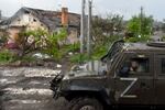 A Russian military vehicle painted with the letter Z drives past destroyed houses in the Ukrainian city of Mariupol on Wednesday.