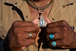 Rodeo contestant and U.S. Army veteran Quincy Cole won the Wild Cow Milking event at last year's Round-Up. Here, he shows his cow tag, bearing a Q for Quincy, and a Cuban link necklace, paying homage to his upbringing in the hip-hop era.