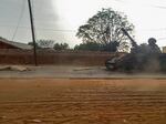 A covered body across from an armored vehicle on a street in the West Darfur state capital El Geneina on June 16, amid ongoing fighting between forces led by two generals in Sudan.