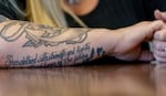 A tattooed verse from the Bible on Lisa Whipple's arm reads: “She’s clothed with strength and dignity, she laughs without fear of the future.” 