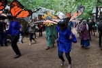 Human butterflies and sunflowers move against the crowd of fair goers.