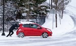 A driver gets a push after being stuck in the snow, in southwest Portland, Feb. 23, 2023. Heavy snowfall began on Wednesday afternoon, making it the second-snowiest day ever recorded in the city. 