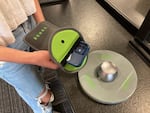 Liliana Garcia, an eighth grader, holds her phone and Yondr pouch over an unlocking device at Walla Walla's Pioneer Middle School.