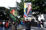 Supporters of Venezuela's current and former president, Nicolas Maduro and the late Hugo Chavez, hold posters with their images in Caracas on Saturday.