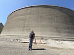 EWEB Water Group principal engineer Laura Farthing is dwarfed by one of the newly constructed water tanks on College Hill in Eugene, Ore., Sept. 9, 2026. The two water tanks are 35 feet tall, made of prestressed concrete and each holds 7.5 million gallons.