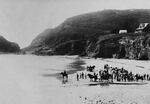 In this image from 1892, people gather on the beach below Heceta Head. Excavation for the lighthouse can be seen on the bluff.