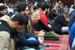 Muslim men listen to Imam Omar Suleiman speak at the Islamic Center of Detroit in Detroit.
