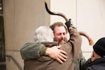 Occupation supporter Brand Nu Thornton, left, raises his shofar and hugs fellow supporter John Lamb after seven occupiers of the Malheur National Wildlife Refuge in eastern Oregon were found not guilty.