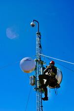 FILE - A technician works on an OHAZ camera attached to a communications tower at Jackass Butte in Oregon.
