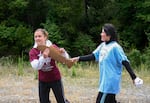 Runners take turns passing carved wooden salmon batons to the next person as they complete their portion of the race.