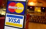 FILE - MasterCard and Visa credit card logos are shown at the entrance of a New York coffee shop, April 22, 2005.