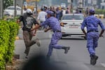 Security personnel detain a protester during a demonstration by the Cockroach Janta Party demanding the resignation of Chief Election Commissioner Gyanesh Kumar in New Delhi, India, Saturday, Oct. 10, 2026.