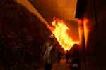 Firefighters protect structures from the advancing Palisades Fire in the Pacific Palisades neighborhood of Los Angeles.