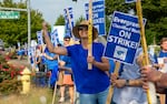 A line of teachers hold signs during a union picket.
