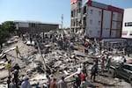 Residents and rescue workers search through the rubble of a collapsed building after an earthquake struck Cali, Colombia, Monday, Aug. 10, 2026.