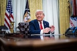 President Trump speaks to reporters and signs an executive order in the Oval Office on March 31.