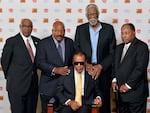 In this Sept. 27, 2014, file photo, back row from left, John Wooten, Jim Brown, Bill Russell, and Bobby Mitchell stand behind Muhammad Ali. In 1967, all five of these men attended "The Cleveland Summit," an event organized by Brown. It brought together prominent Black athletes of the time as a show of support for Ali, who faced charges after he refused to join the military during the Vietnam War.