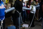 In this photo contributed by Oregon State University student Mya Kraus, students protesting the war in Gaza are chained to a campus administration building. Student-protesters began a 100-hour protest on Thursday, June 6, 2024.