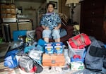 Brook Gowin poses for a photo with the supplies she has left after living off of her her emergency preparedness kit for a weekend.