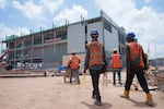 FILE -Construction workers walk to a data center building under construction in Sedenak Tech Park in Johor state of Malaysia, Sept. 27, 2024.