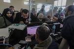 Palestinians who are foreign passport-holders get their documents checked to enter Egypt from the Gaza Strip through the Rafah border on Feb. 6. For most in Gaza — without foreign passports or approved reasons to leave such as for medical care — the only pathway out is to pay.